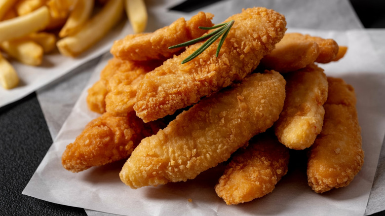 Chicken tenders with fries in the background