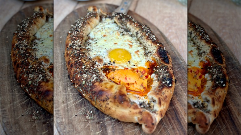 Khachapuri with za'atar and Calabrian chili butter on cutting board.