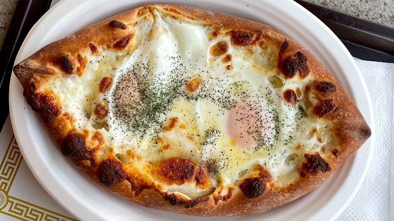 Khachapuri on a white paper plate