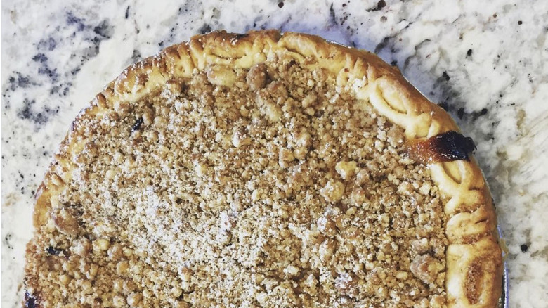 apple crumb pies sprinkled with powdered sugar on marble countner