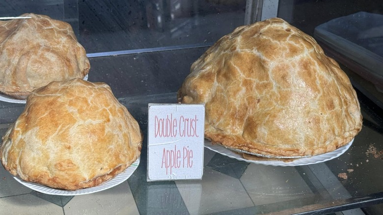 very tall double crust apple pies in case