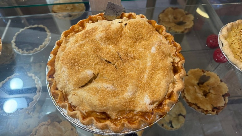 homemade apple pie in glass case, among other pies