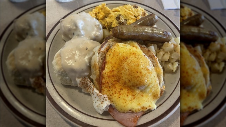 A plate of biscuits and gravy, sausages, home fries, and other brunch items.