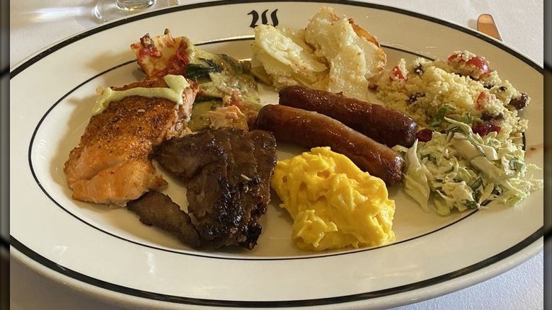 Sausage, eggs, and bacon on a plate, from brunch buffet.