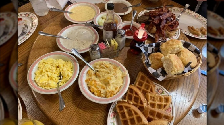 Waffles, eggs, and more on a wood, lazy Susan-style table.