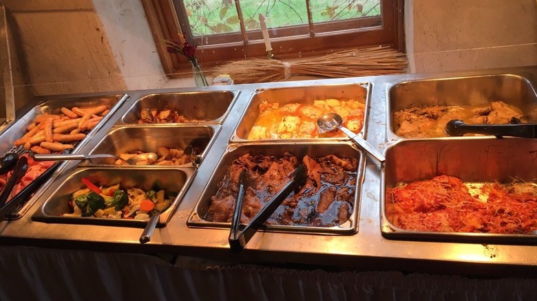 Brunch buffet, with food in metal, recessed serving dishes.
