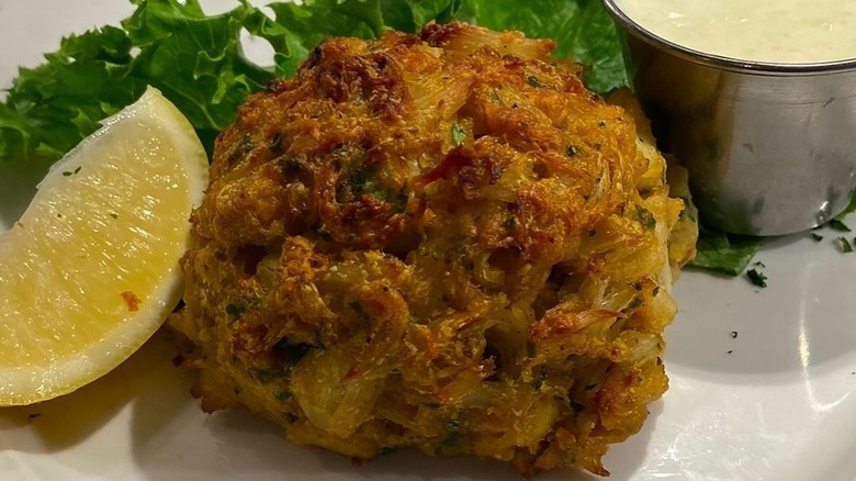 Crab cake on plate with lemon wedge