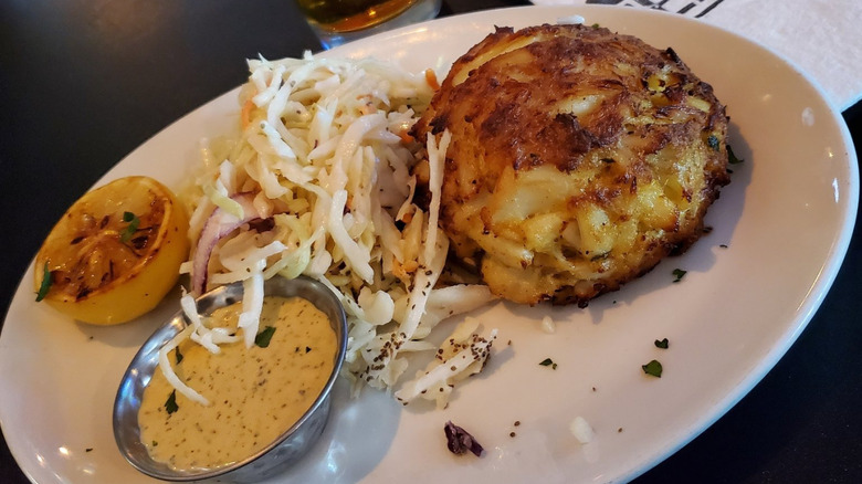 A crab cake and coleslaw on a plate