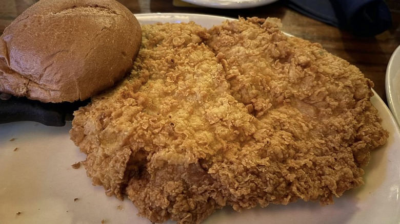 pork tenderloin on plate with bun on side