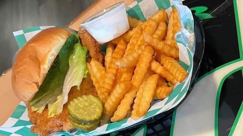 pork tenderloin sandwich with lettuce and pickle and crinkle cut fries