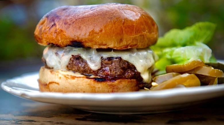 Rootstock burger platter with a cheeseburger, salad leaves, and pickles