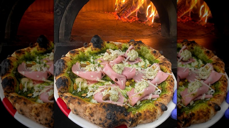 An AMA Pizza e Cucina coming out of the wood-fired oven
