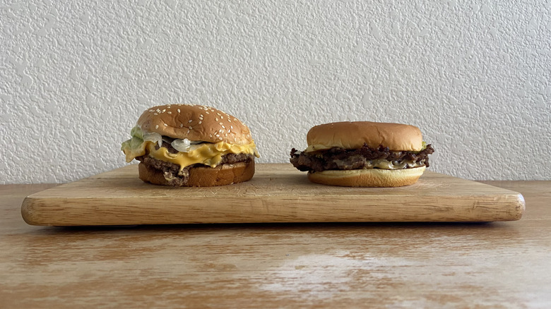 two smash burgers on a wooden cutting board