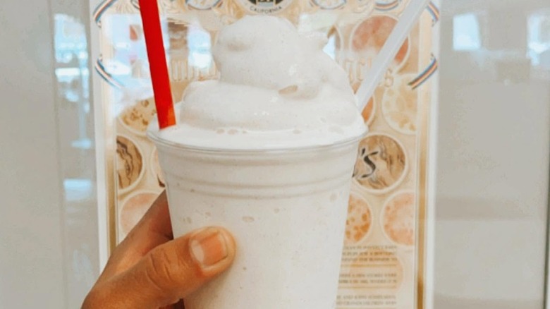 Horchata milkshake from Fosselman's, in plastic cup with one white and one red straw.
