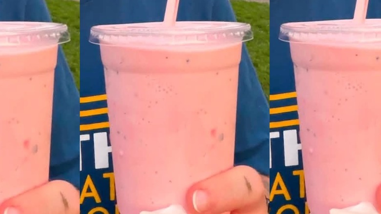 Pink milkshake in plastic cup.