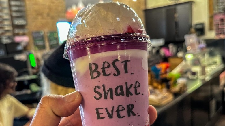 Huckleberry shake in hand, with Best. Shake. Ever. written in black marker on plastic cup.