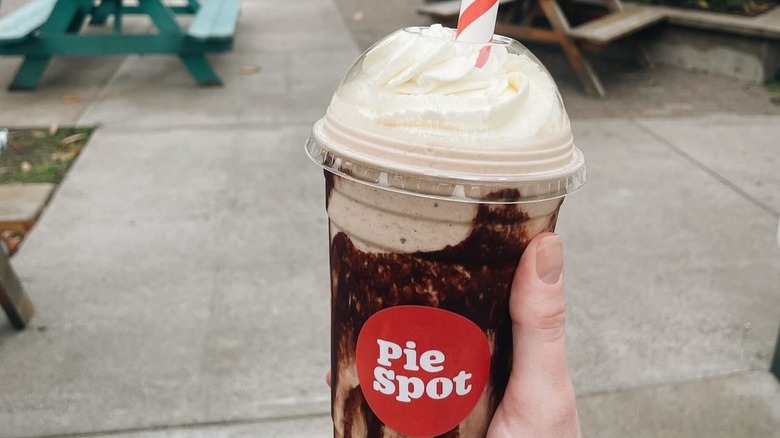 Chocolate shake with whipped cream in Pie Spot plastic cup.