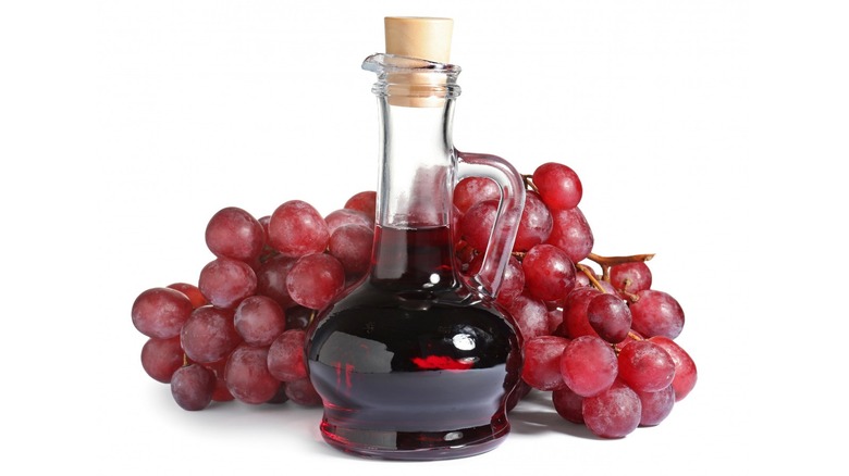 glass wine vessel with grapes