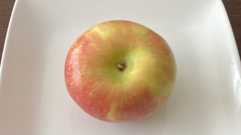 Fuji apple on white plate