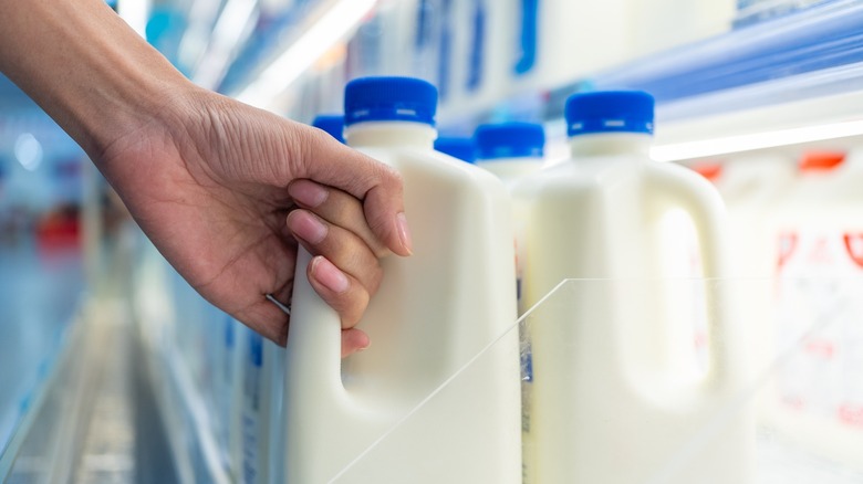Shopper picking up carton of milk