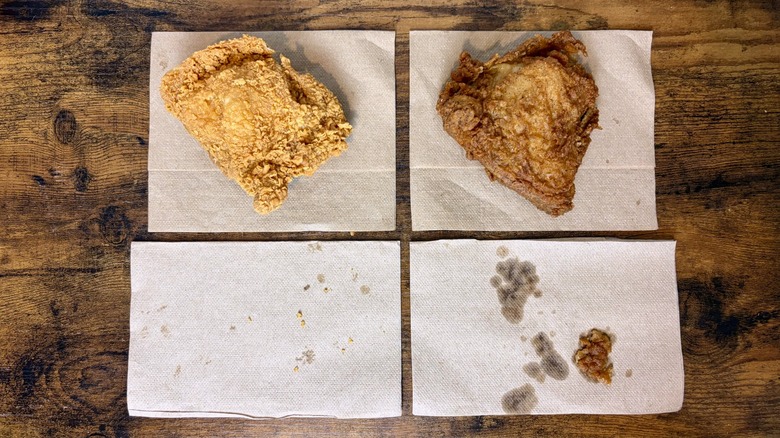 Two pieces of fried chicken side by side on napkins to show greasiness