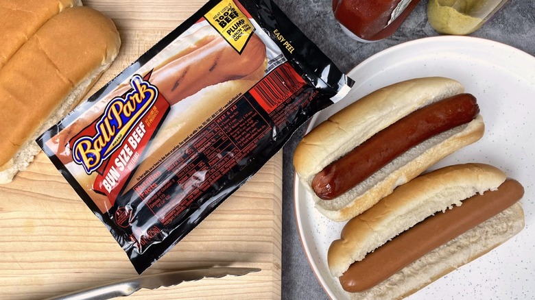 A package of Ball Park hot dogs beside a plate of two hot dogs