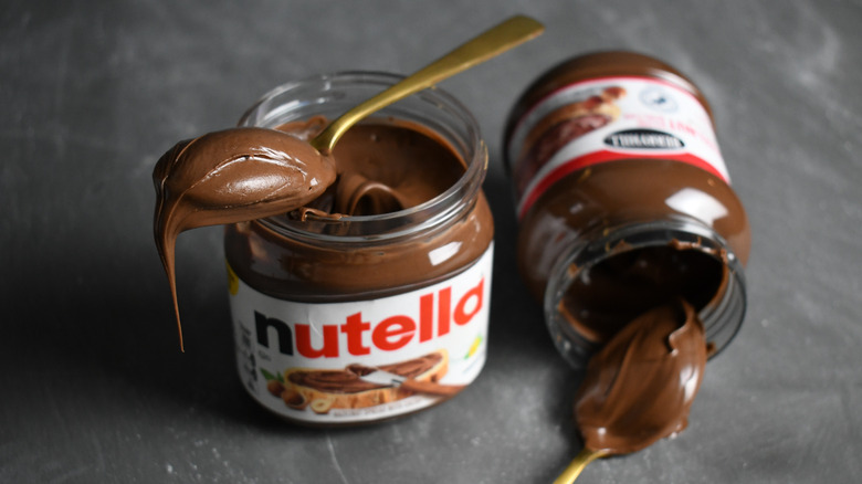 Jars of Nutella and ALDI Berryhill hazelnut spread with spoonfuls of spread