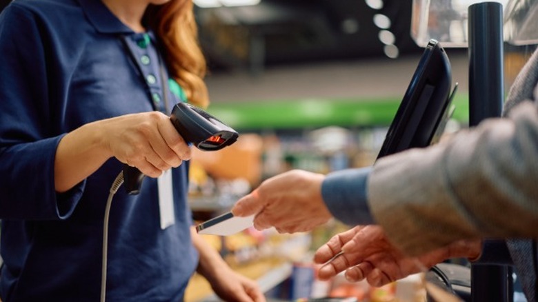 A cashier scanning coupons