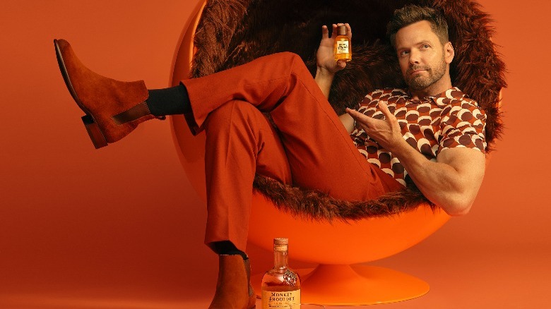 Joel McHale holding perfume bottle