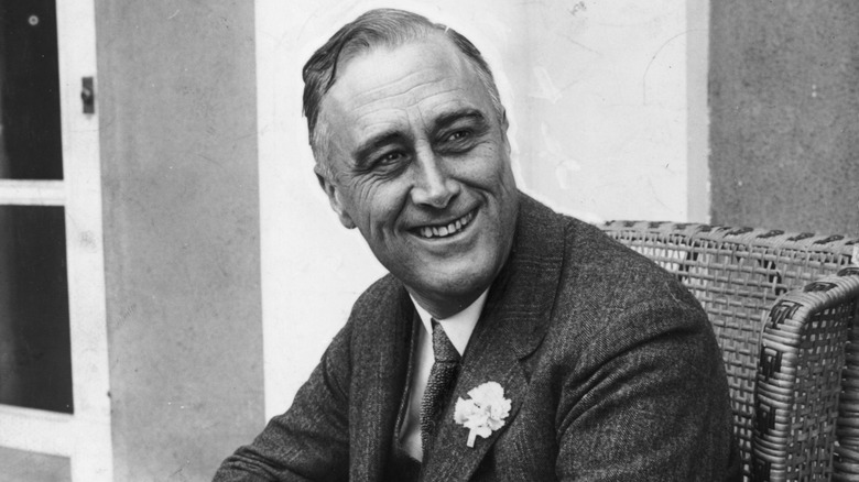 President Franklin Delano Roosevelt smiles with his head tilted to the side.