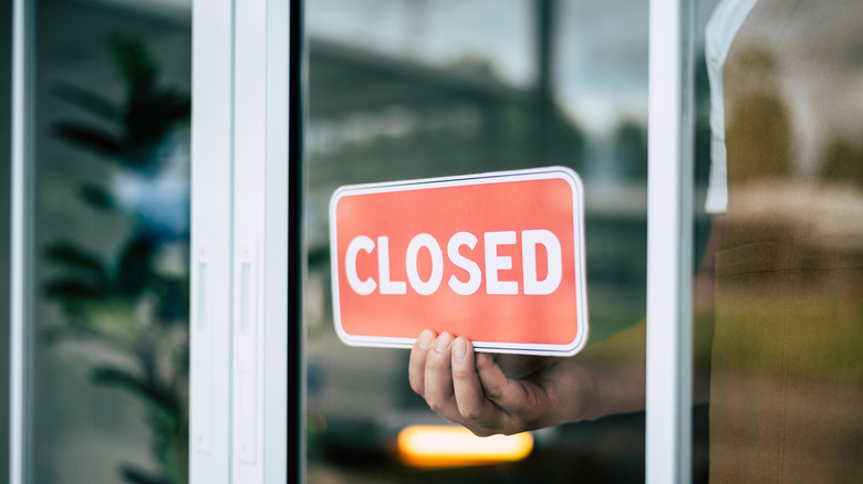 Restaurant employee putting up closed sign