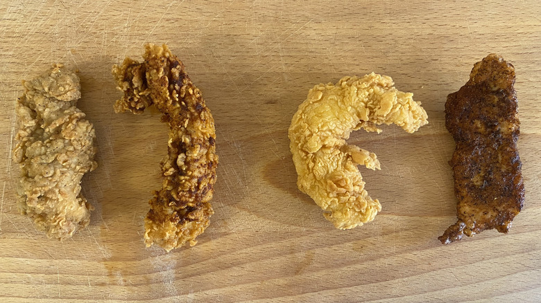 A top-down view of one of each tenders from KFC and Popeyes on a cutting board