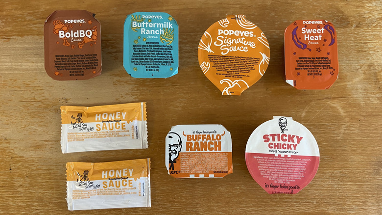 A top-down view of a variety of KFC and Popeyes sauces