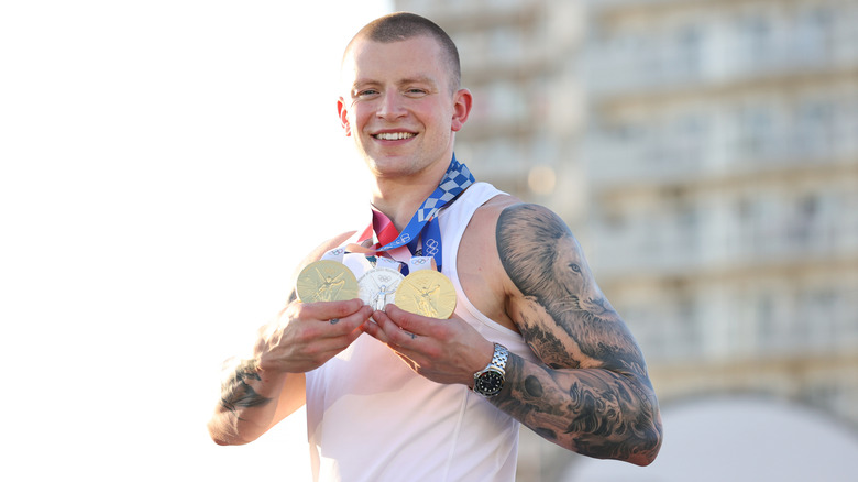 Adam Ramsay-Peaty with his two gold medals and silver medal from the 2020 Tokyo Olympic Games.