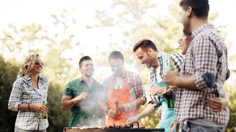 group of people gathered around a grill