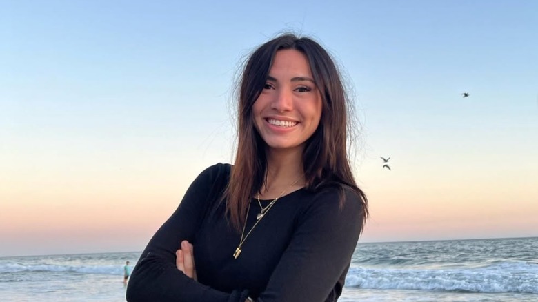 Haley Pham smiling with arms folded by the ocean