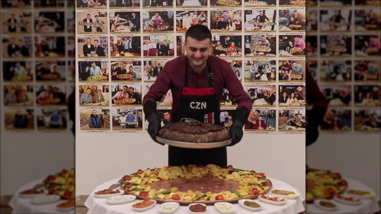 a screenshot of CZN Burak's first TikTok video in 2018 holding a large pan of meat dish