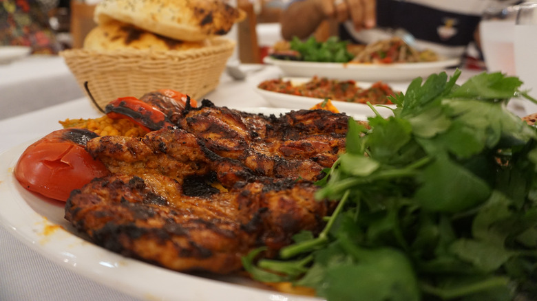 Seasoned grilled chicken with greens and tomatoes served at the Hatay Medeniyetler Sofrasi restaurant owned by CZN Burak, real name Burak Ozdemir