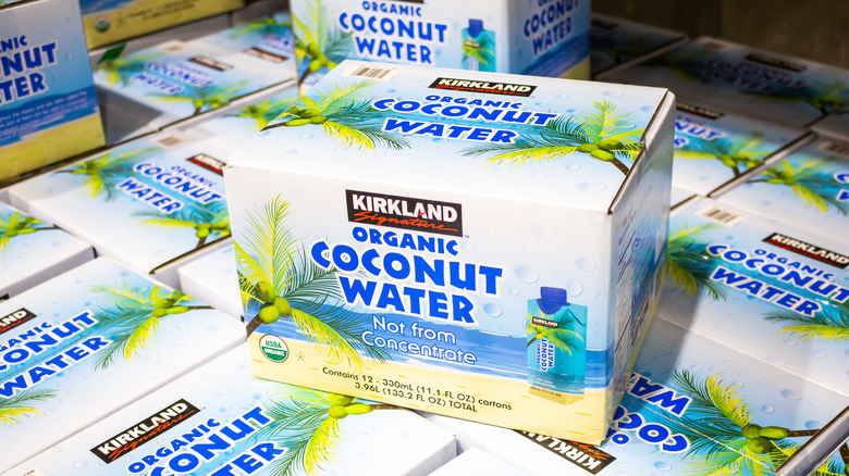 Box of older version of Kirkland Signature organic coconut water sitting on top of other boxes