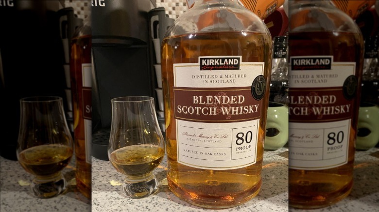 A glass and bottle of Kirkland Signature blended Scotch whisky from Costco