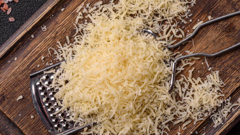 Shredded parmesan cheese on a wooden block
