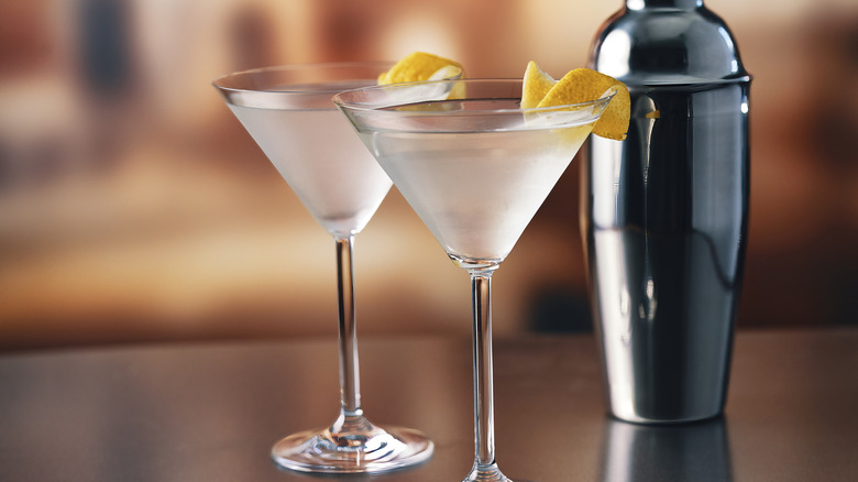 Two martini glasses with clear spirits and lemon twists