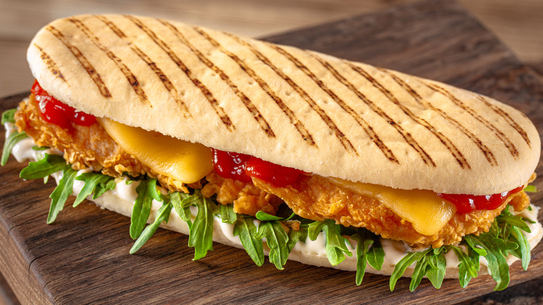 Panini sandwich with sauce, chicken, and salad