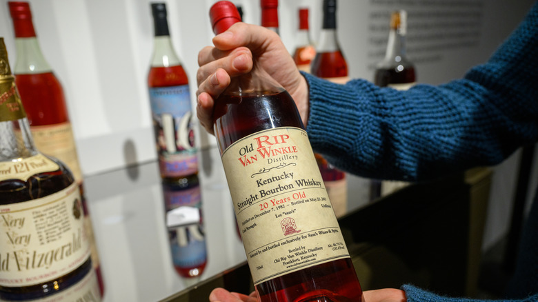 Hands holding Old Rip Van Winkle 20-year-old single barrel "Sam's" bourbon