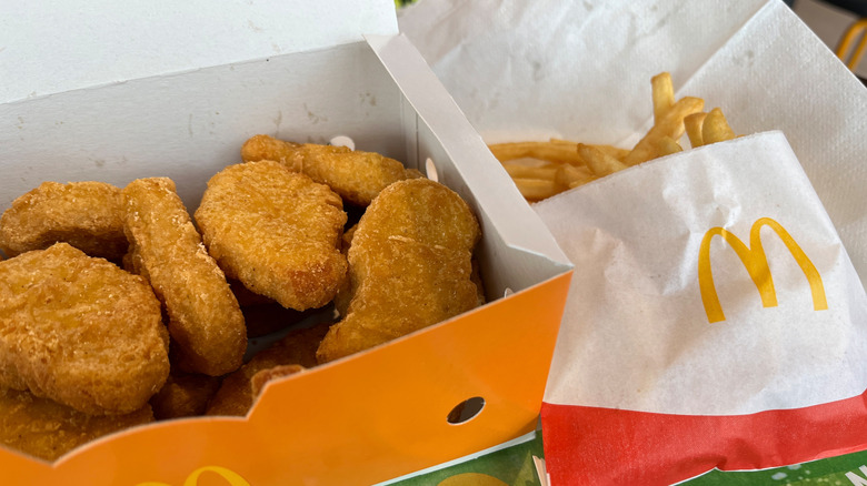 Box of chicken McNuggets next to small bag of fries.