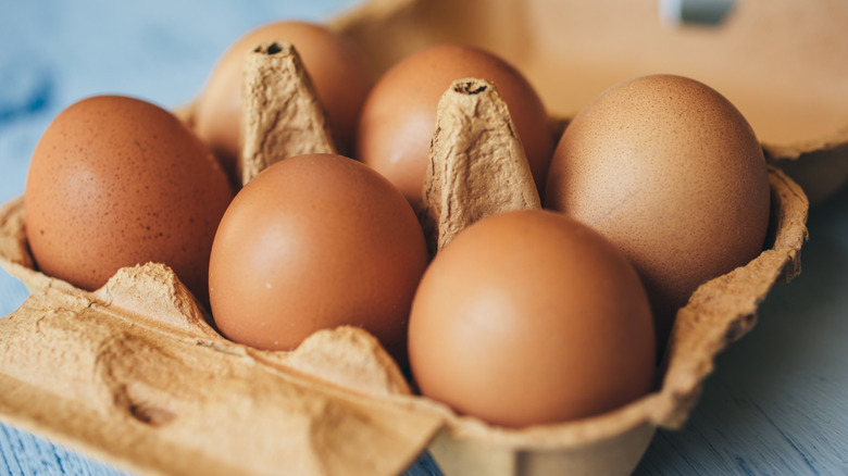 Six brown eggs in a carton tray