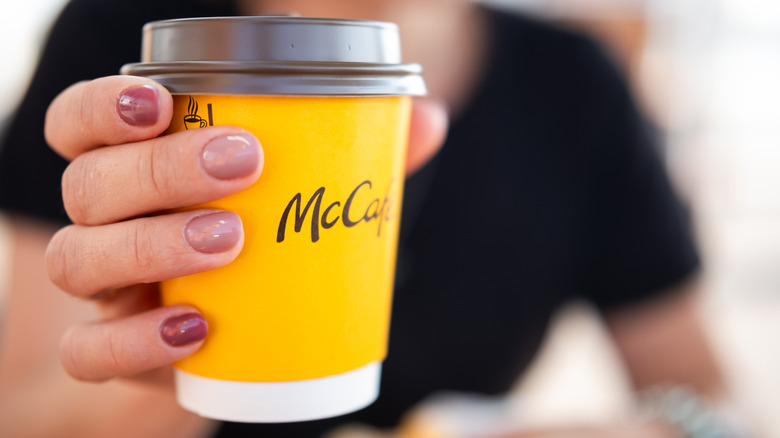 A woman holds a takeout cup of McDonald's brewed coffee