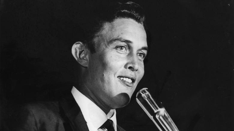 Black and white photo of Jimmy Dean standing before a microphone