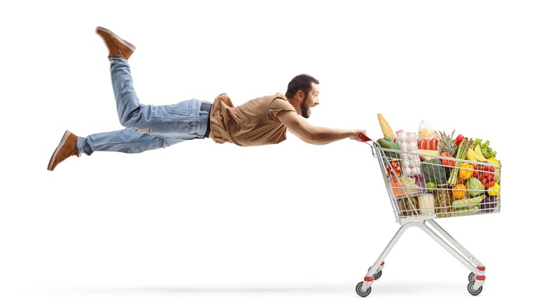 man flying on shopping cart