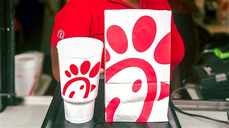 Chick-fil-A worker behind restaurant bag and drink